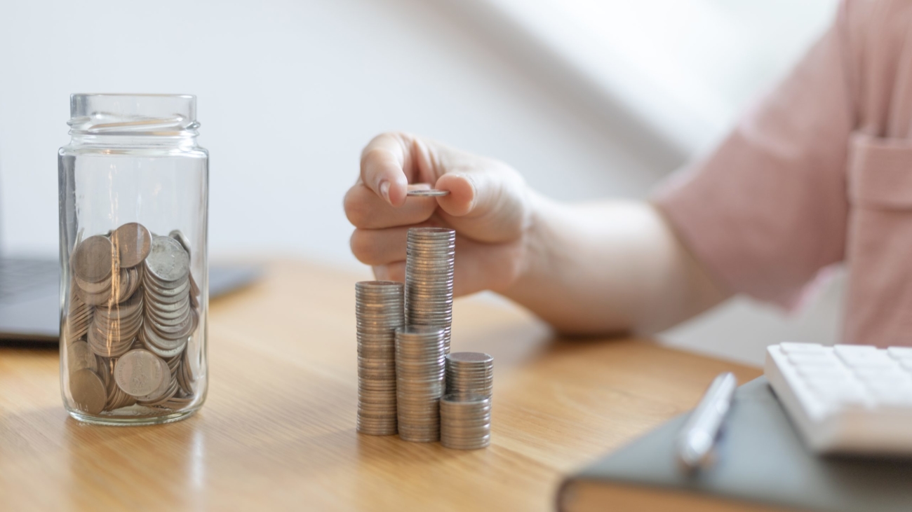 Woman's hands put the coins arranged in steps, Managing your finances or saving money for future use, Saving for investment, Saving money for business growth or long-term profitability.